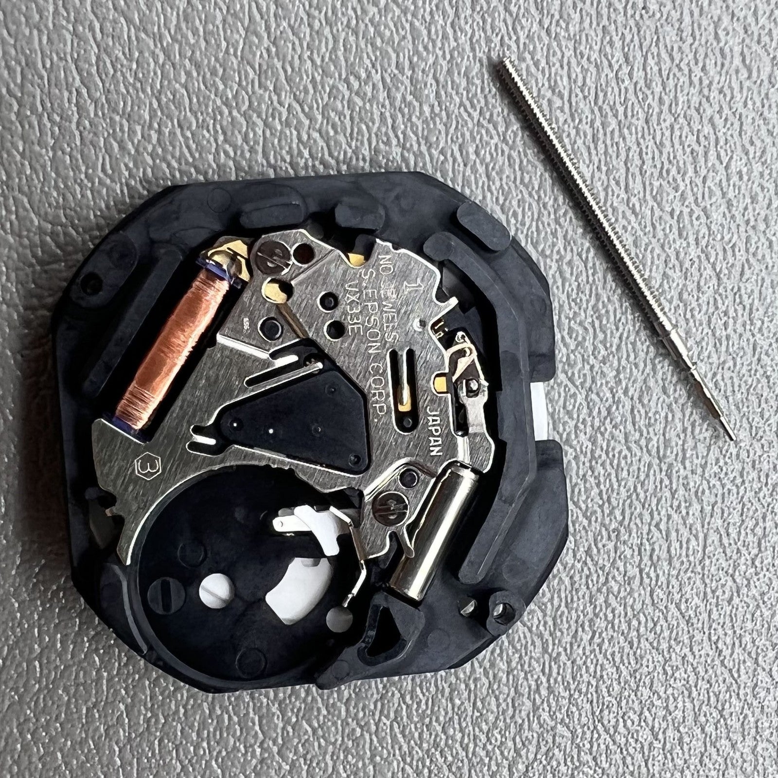 Japan VX33E quartz watch movement with single calendar disk, dual Chinese-English date display, precision timekeeping.