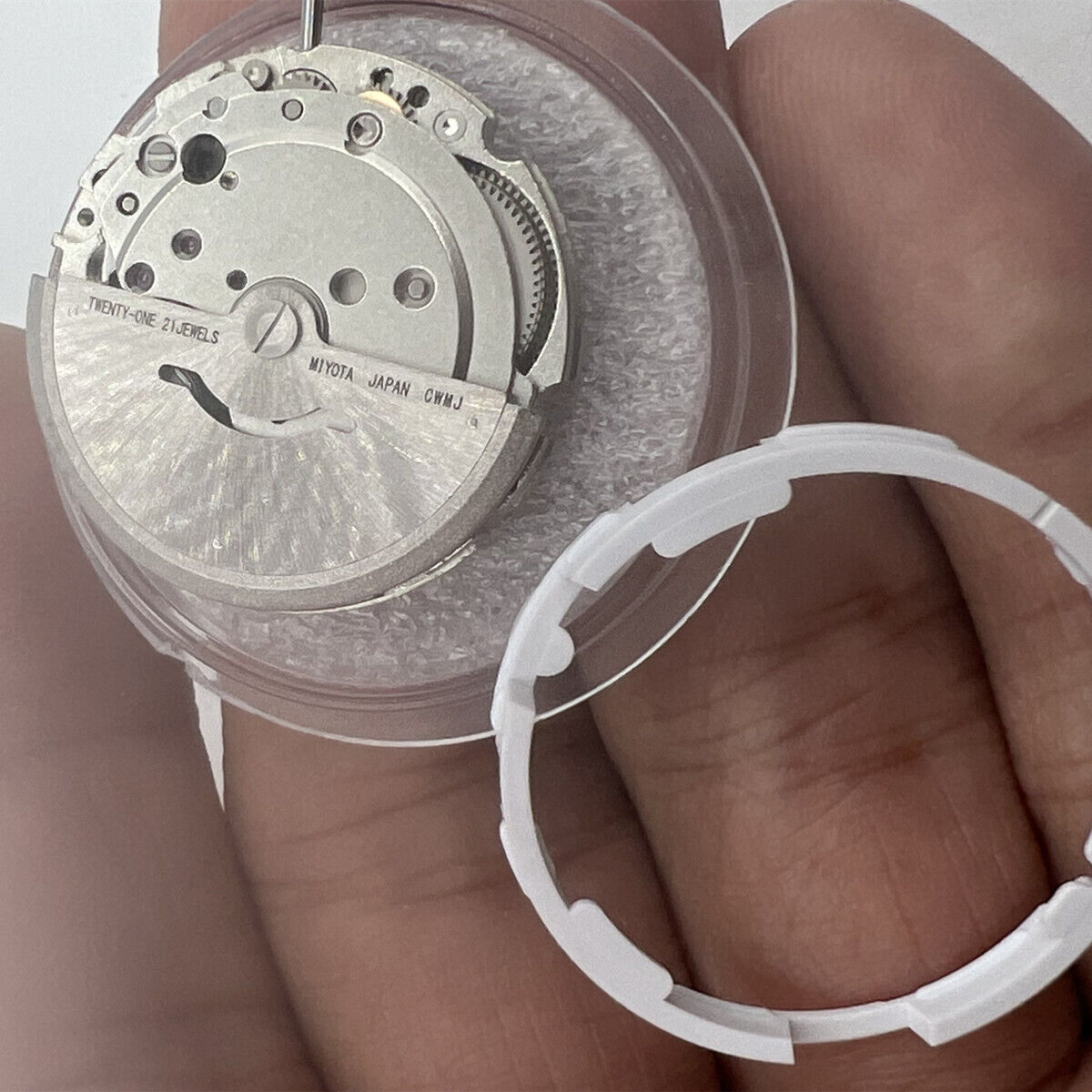 Miyota/Citizen 8215 automatic watch movement with black dial and date display at 6 o'clock.