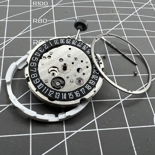Miyota/Citizen 8215 watch movement with black dial and date at 6, automatic mechanical for precision timekeeping.