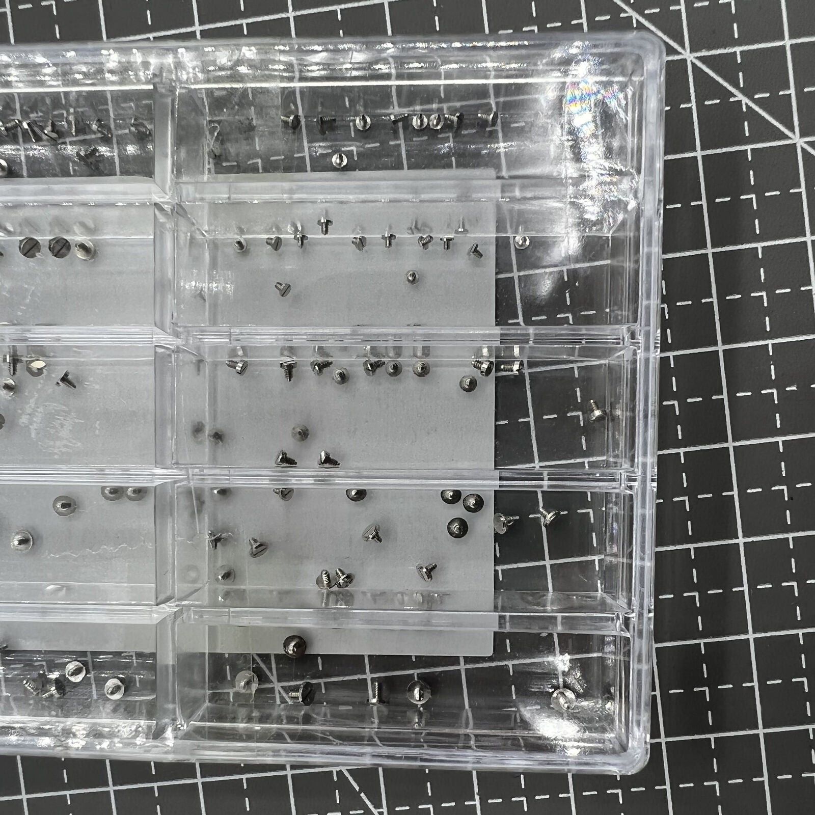 Assortment of watch movement fixing screws in multiple sizes for secure repairs.