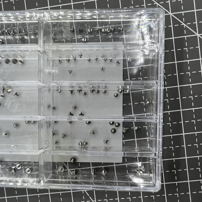 Assortment of watch movement fixing screws in multiple sizes for secure repairs.