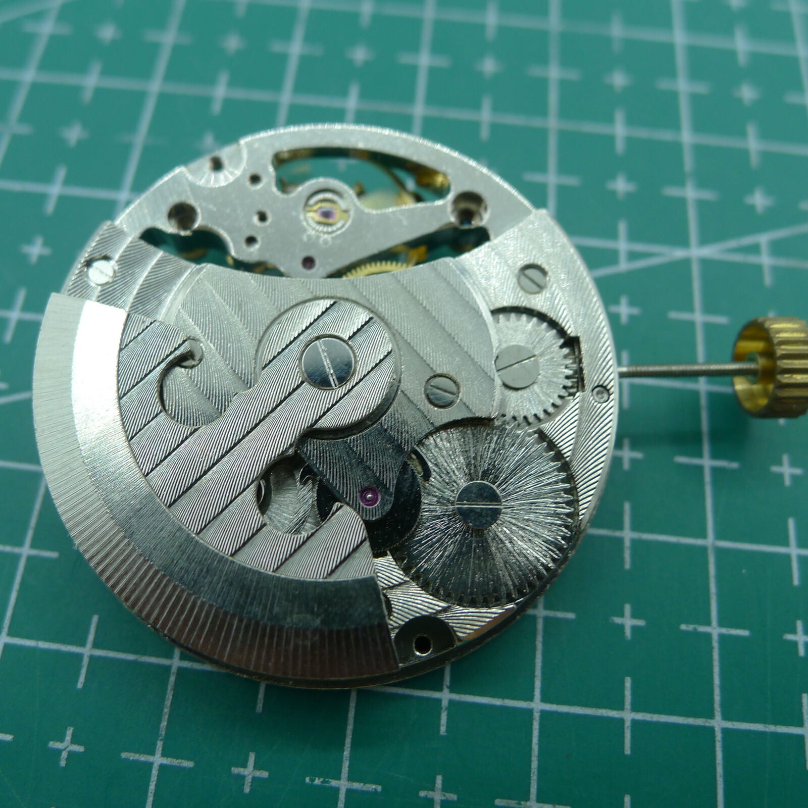 Silver automatic mechanical watch featuring hollow moon phase at 12 o'clock, elegant timepiece design.