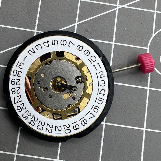 Golden Swiss Ronda 715 quartz watch movement with date display at 3, replacement part.