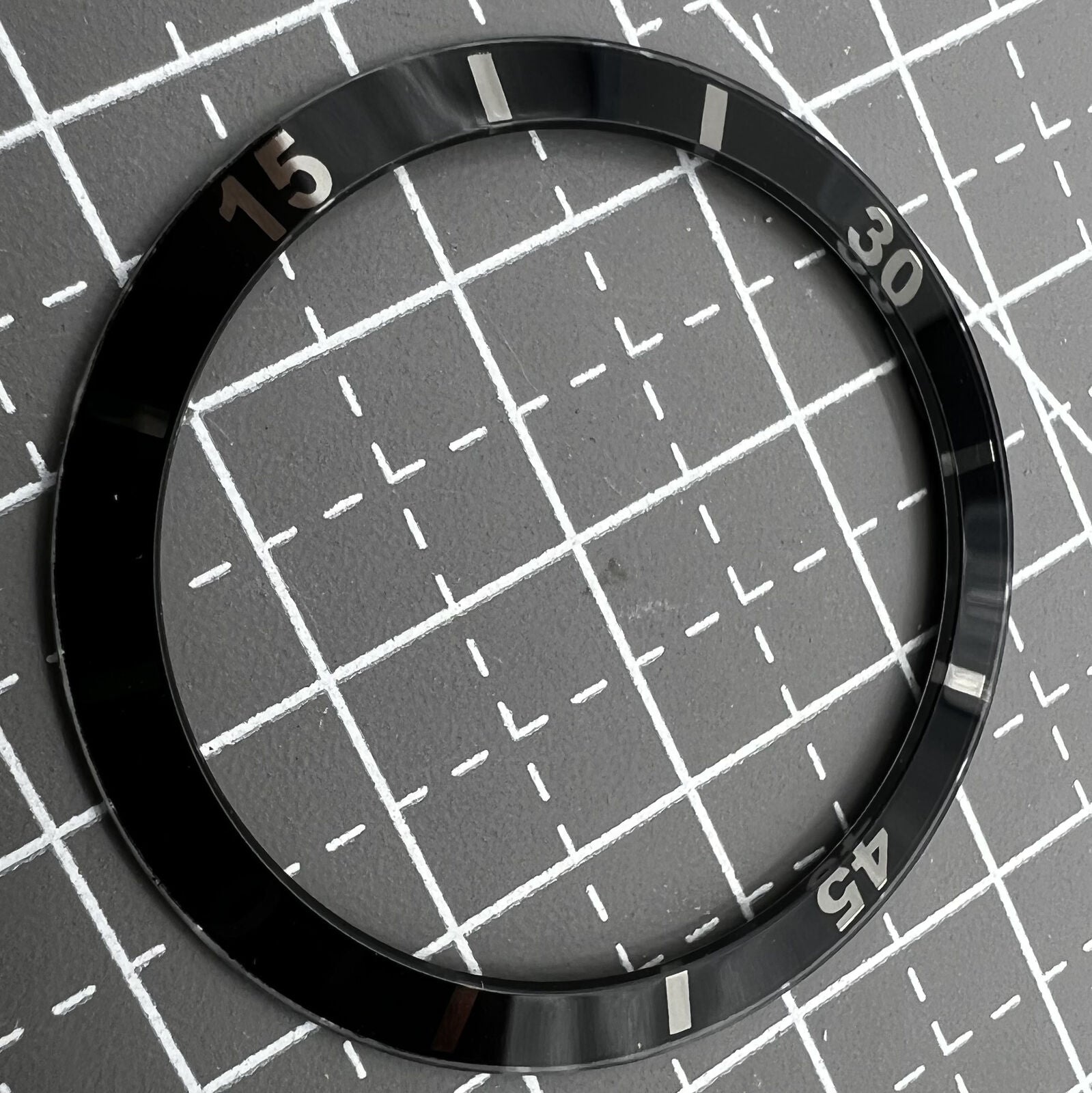 36mm black ceramic bezel insert with white numerals for men's and women's watches.