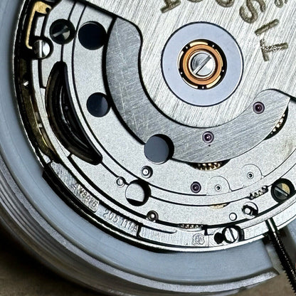 Swiss Made ETA 205.111 watch movement with silver finish and kinetic energy for accurate timekeeping by ETA.