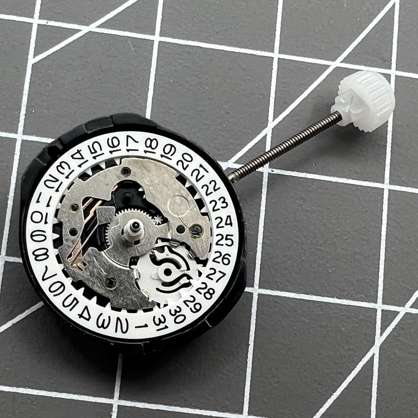 Sunon SL25 quartz watch movement with 3 hands, date window at 3 and 6 o'clock positions.