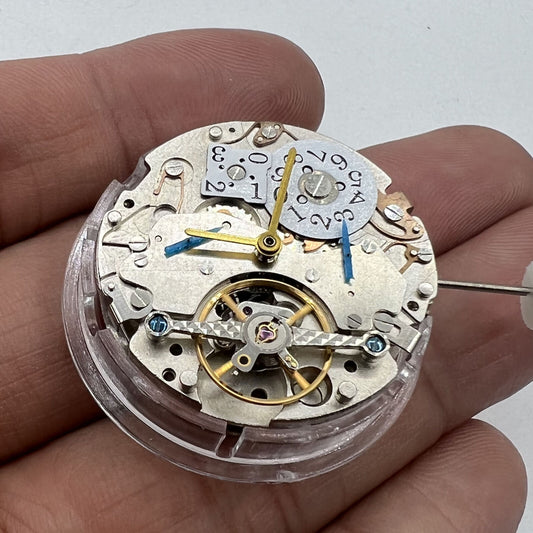 Asian automatic watch with multifunctional date at 12 o?clock and bare balance wheel visible.