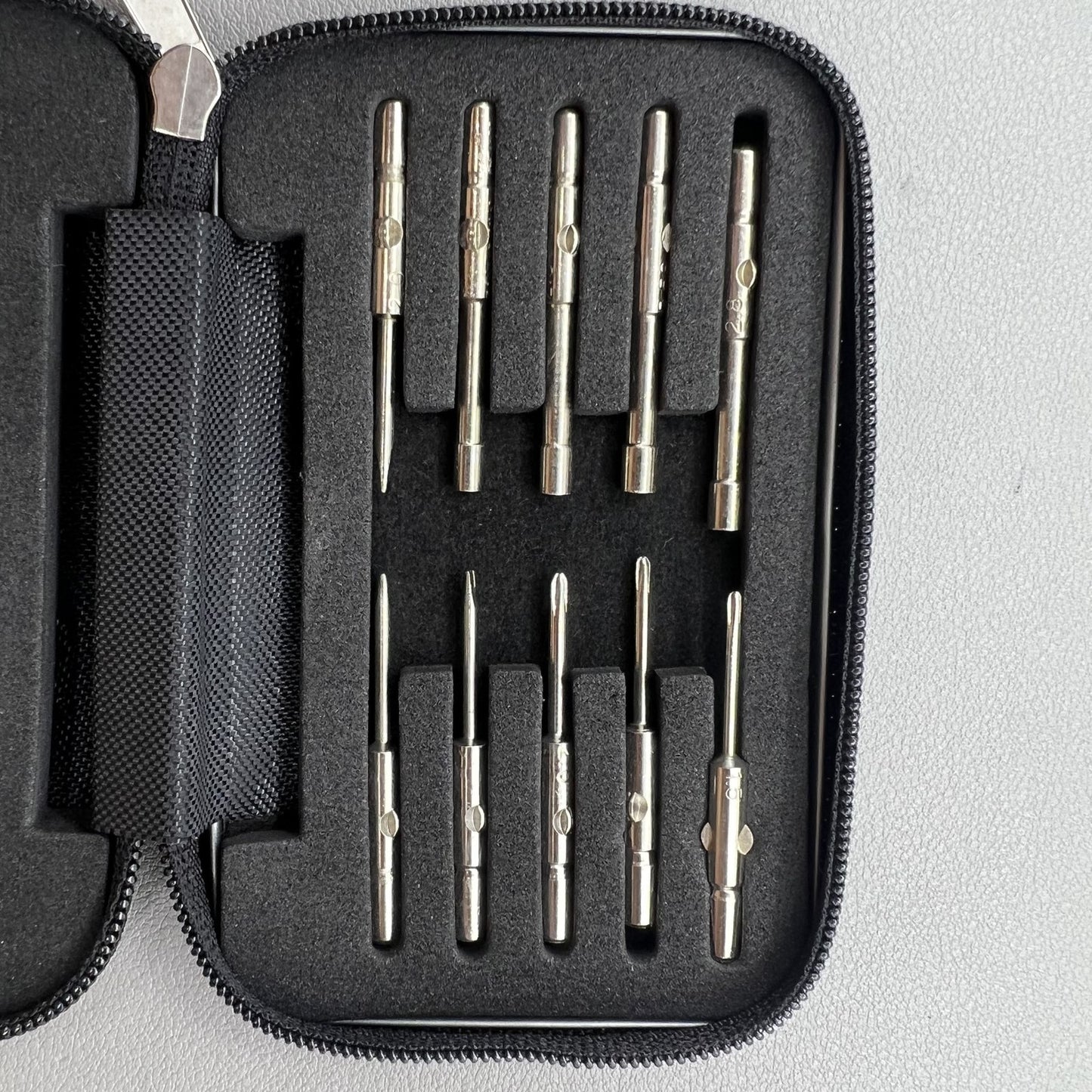 Precision screwdriver set for watch and eyeglass repair, includes hex tools and cutter heads with grip handle.