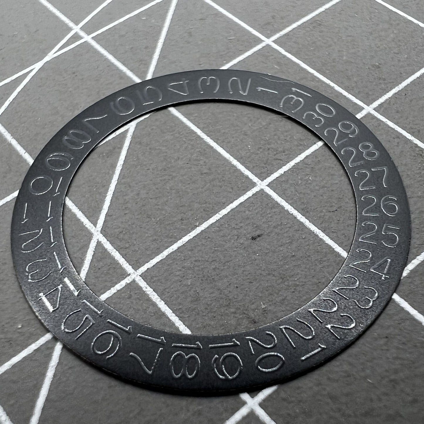 Black background close-up of Grey Character Date Disk for Seiko NH35 NH36 watch movement.