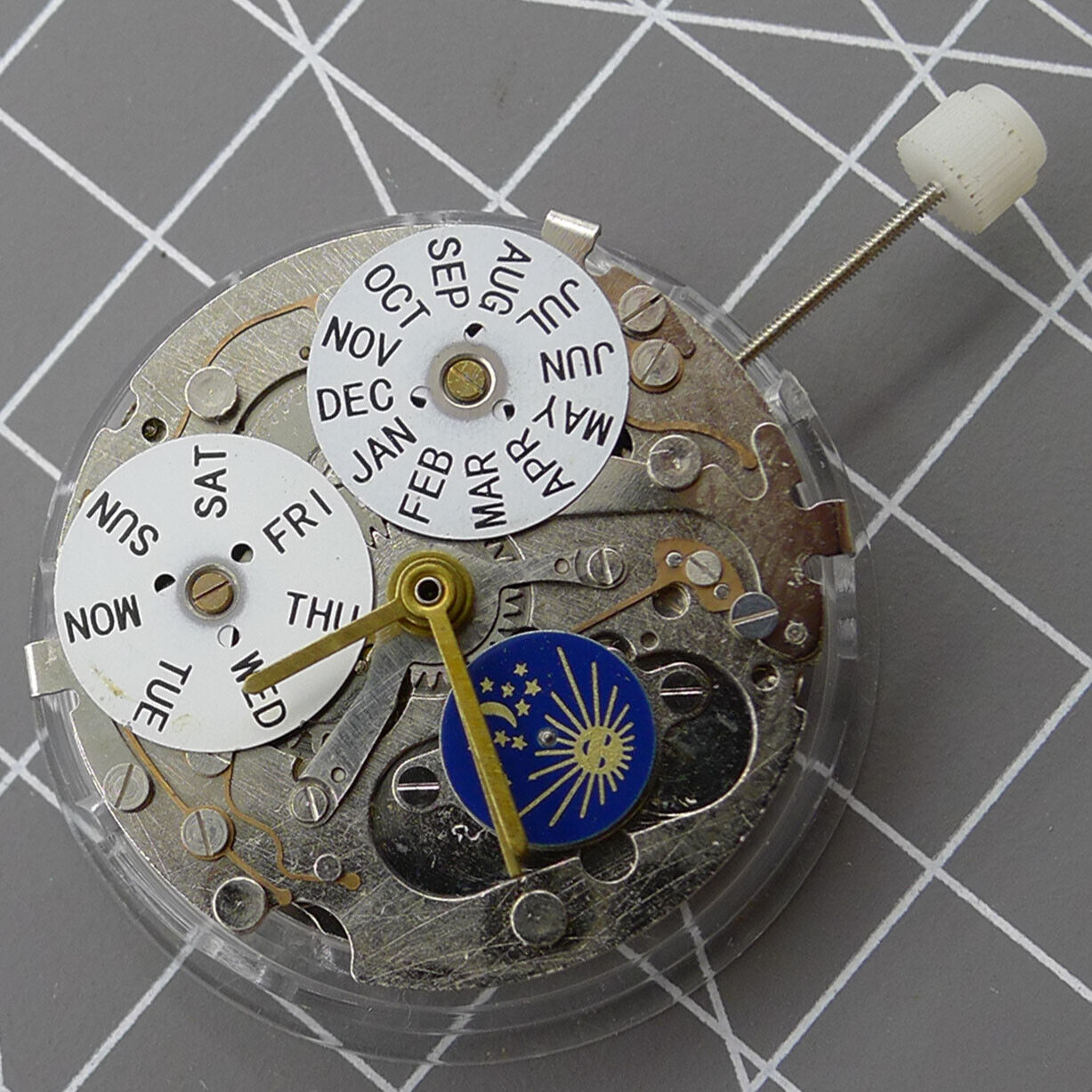 Silver automatic mechanical watch with week/month display at 12 o'clock, moon phase at 6, elegant design.