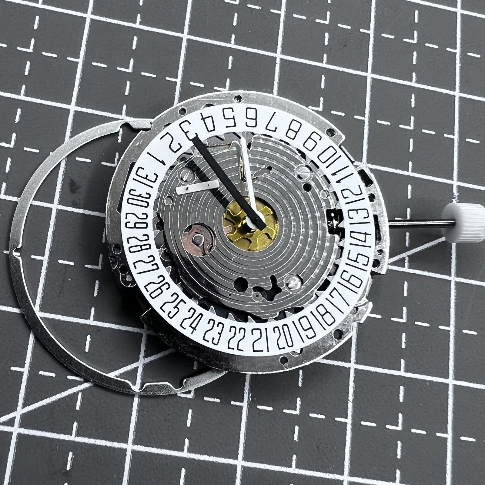 Swiss ISA 8171A quartz watch movement with white dial, four hands, and date at 6 o?clock for precise timekeeping.