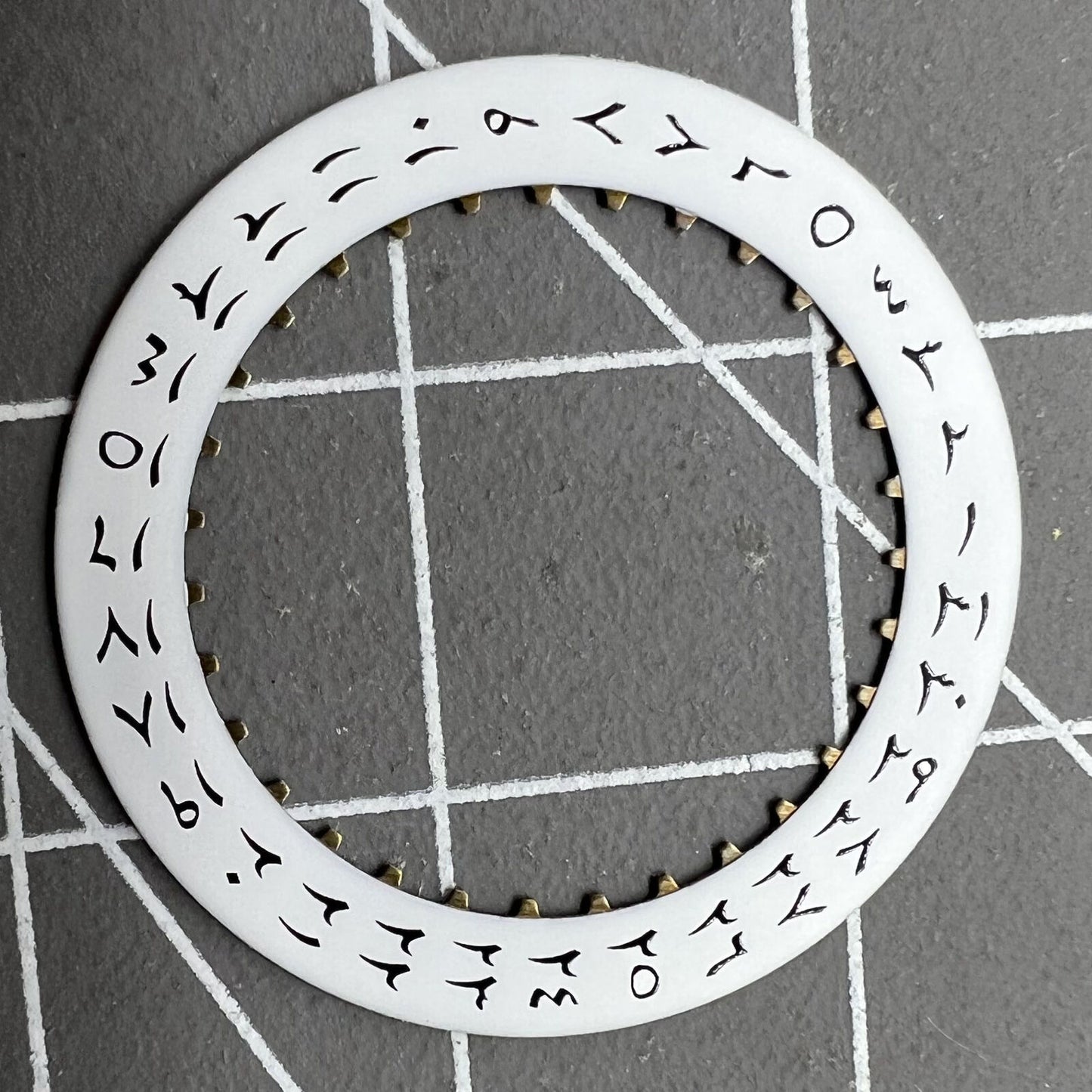 White background close-up of Arabic date disk wheel for ETA2824 Datejust watches, precision component.