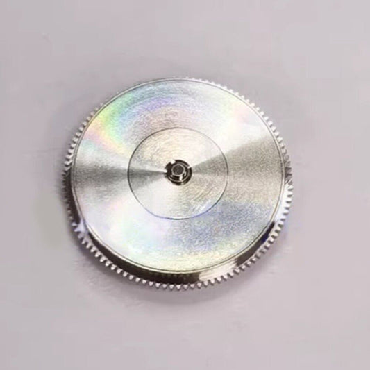 Silver barrel with complete mainspring for Tudor T562 watch movement, enhancing accuracy and durability.