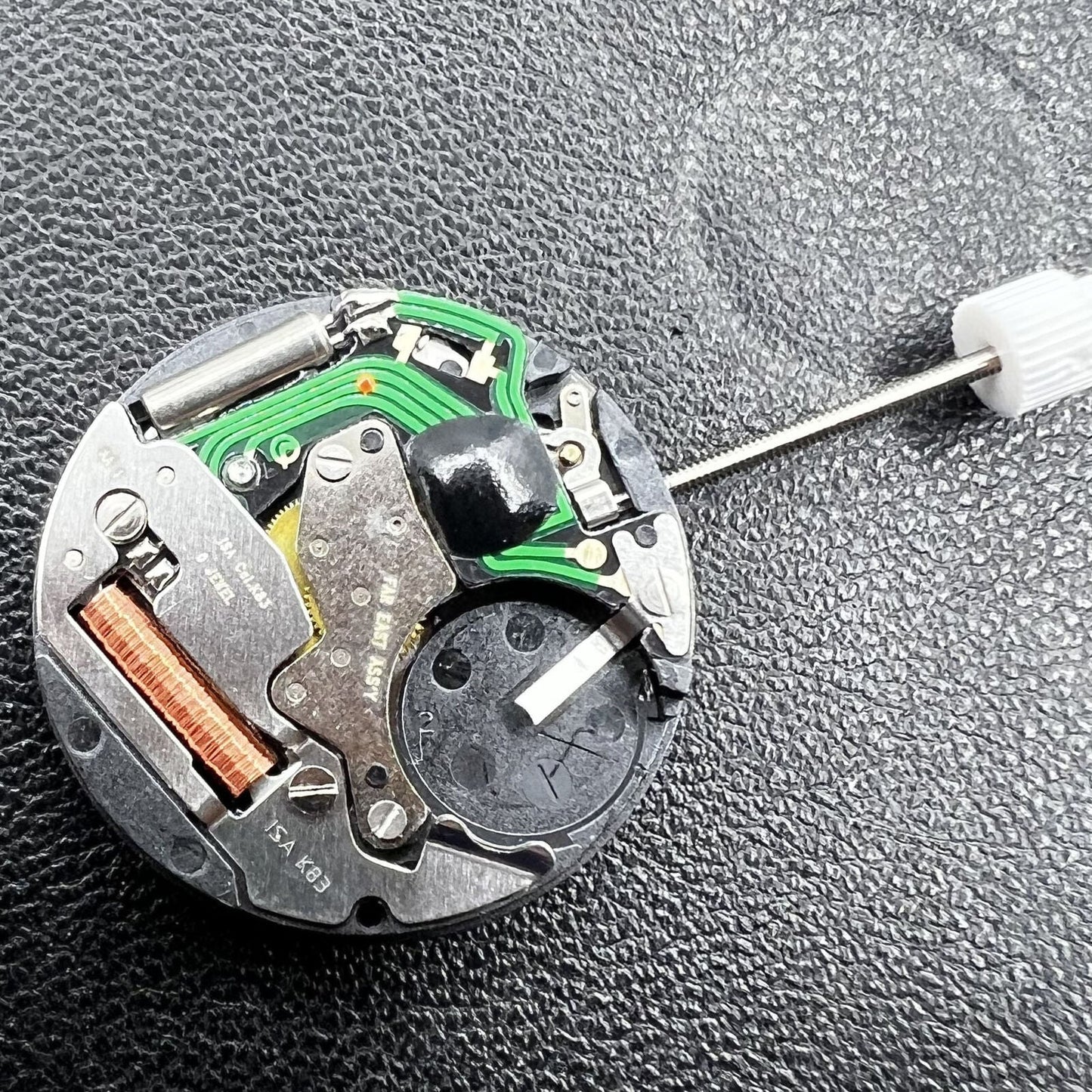 Swiss ISA Quarzuhrwerk K83 103 watch movement with date at 3 o'clock and three hands for precision timekeeping.