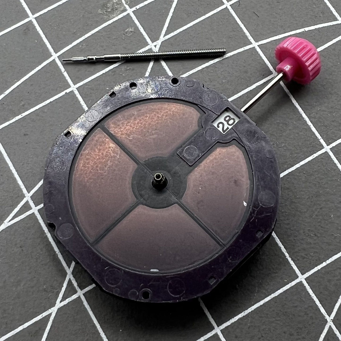 Close-up of Citizen Eco-Drive E168M quartz watch movement with three hands and date window at 3 o'clock.