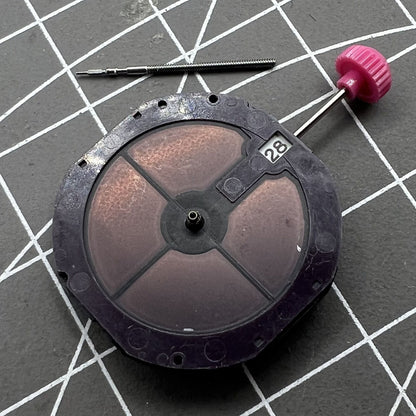 Close-up of Citizen Eco-Drive E168M quartz watch movement with three hands and date window at 3 o'clock.