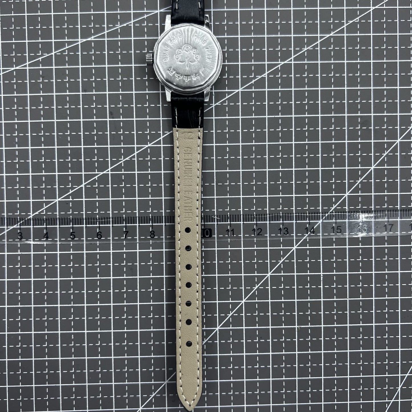 27mm Kongque watch with black leather strap, silver dial, gold markers, and 19-jewel manual mechanical movement.