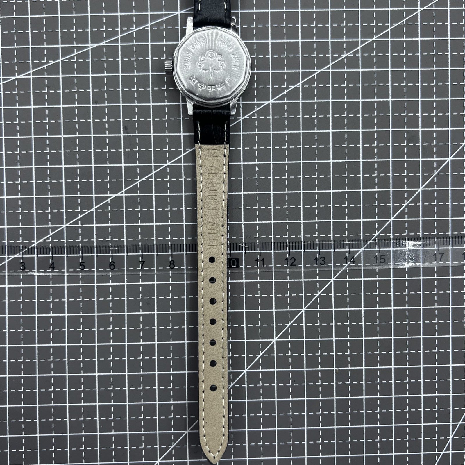 27mm Kongque watch with black leather strap, silver dial, gold markers, and 19-jewel manual mechanical movement.