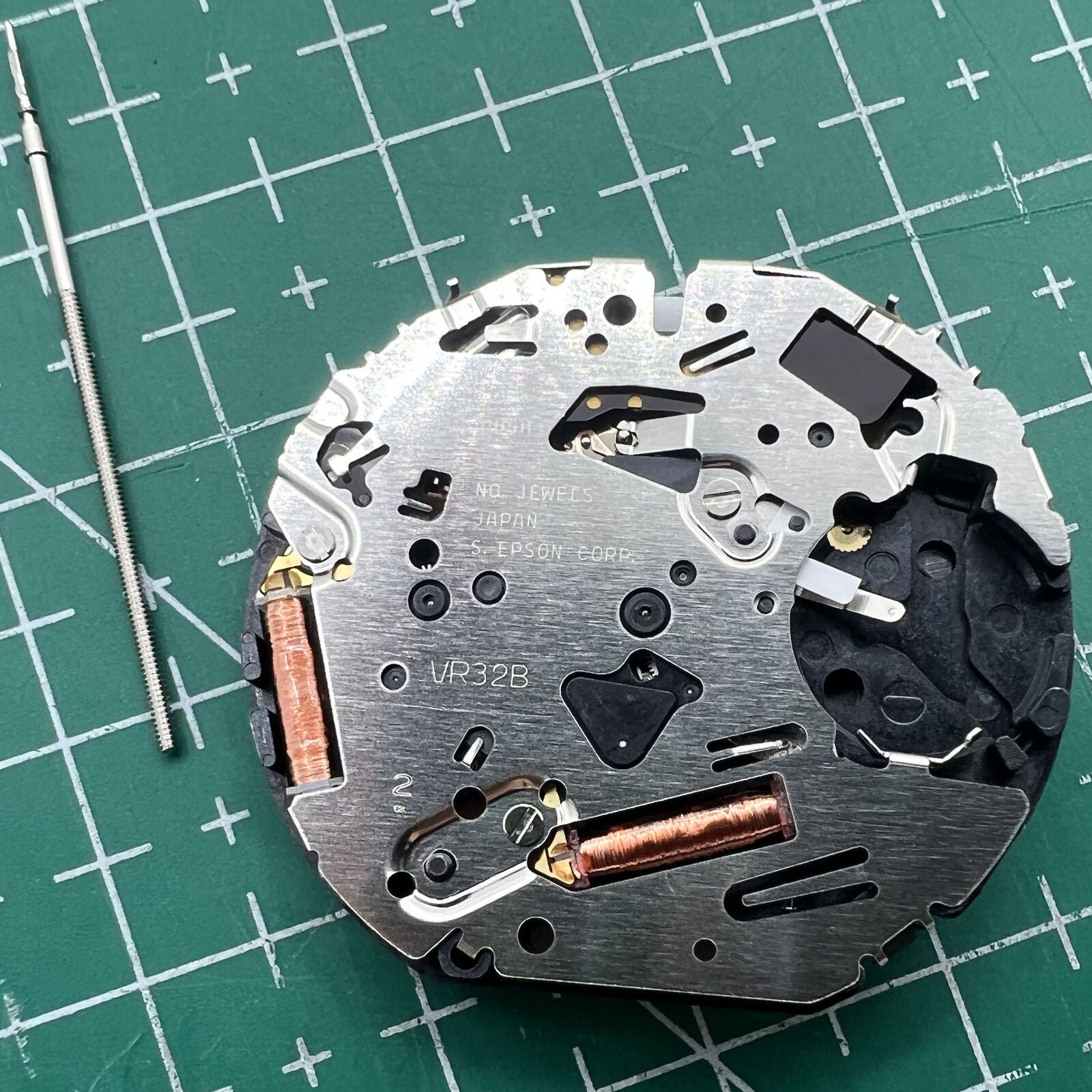 Hattori VR32 Japan quartz chronograph watch movement showing detailed gears and precision components.
