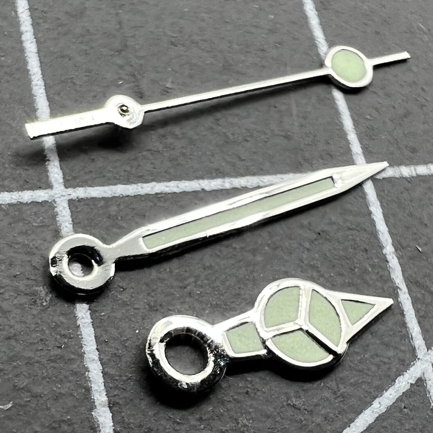 Silver trim green lume watch hands set for Miyota 2035 movement, enhancing visibility and style.