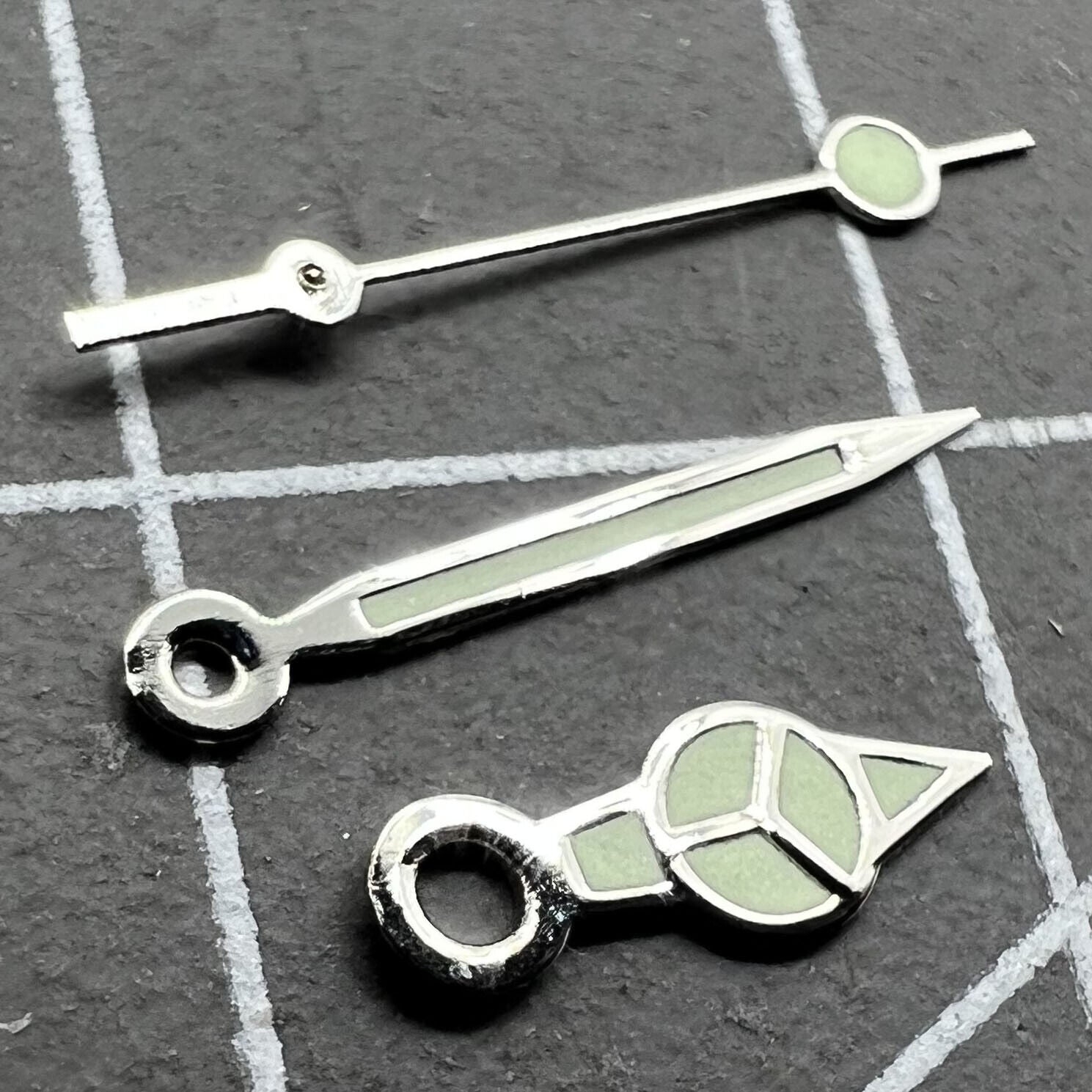 Silver trim green lume watch hands set for Miyota 2035 movement, enhancing visibility and style.