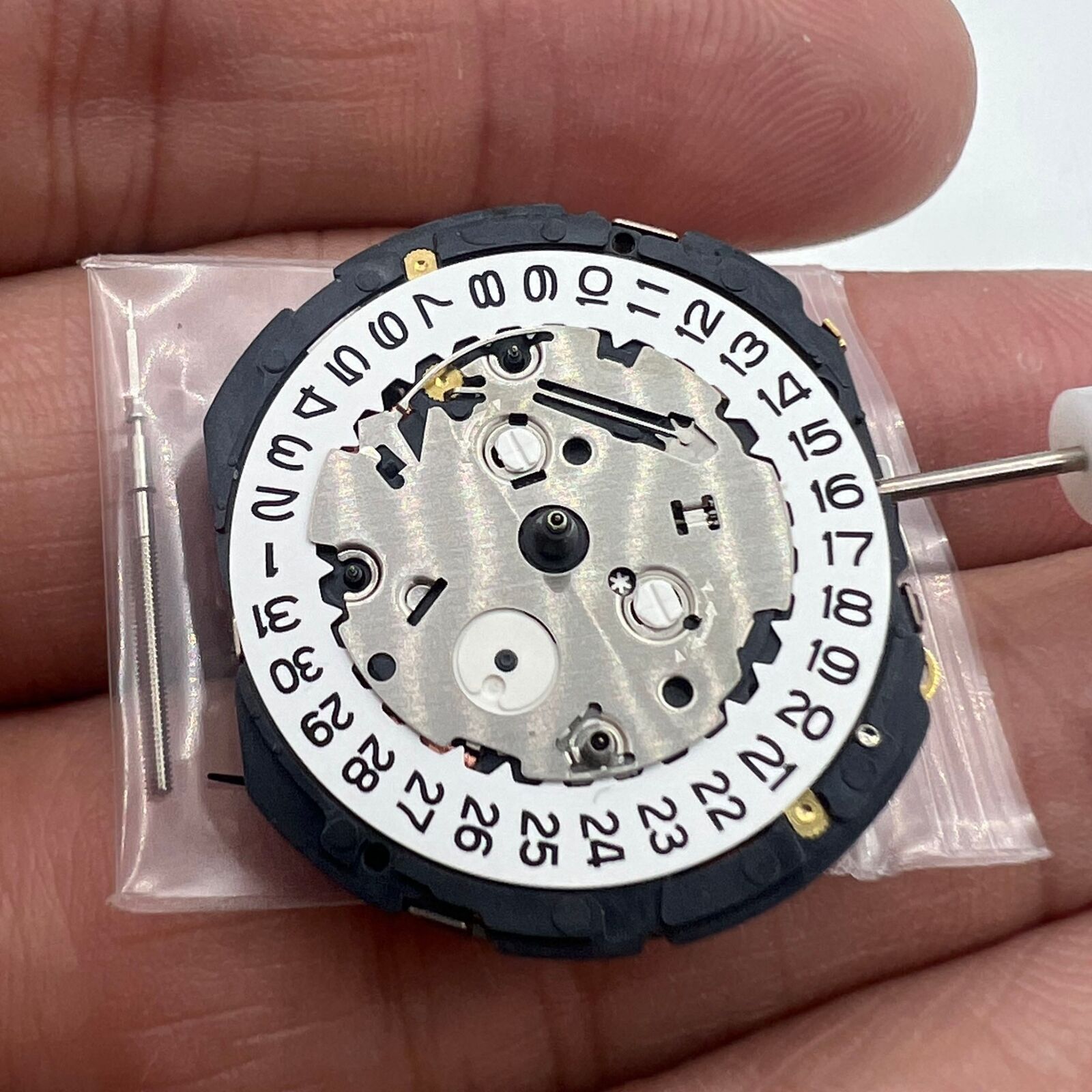 Orient KFB00 quartz watch movement with date at 3, white disk, Japan-made precision replacement.