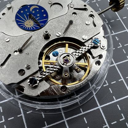 Multifunctional automatic watch featuring mechanical movement and moon phase display at 12 o'clock.