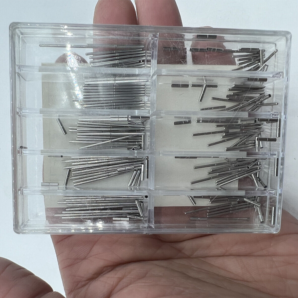 Stainless steel pins with tubes for watch bracelet adjustment, ideal for precise strap repairs.