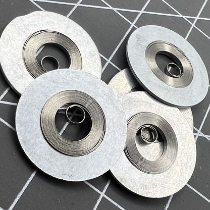 Ressort moteur argenté générique adapté au mouvement 7S26#180. Pièce de montre