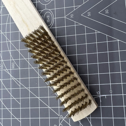 Copper wire brush with wooden handle for rust removal and metal cleaning, perfect for jewelry making tools.