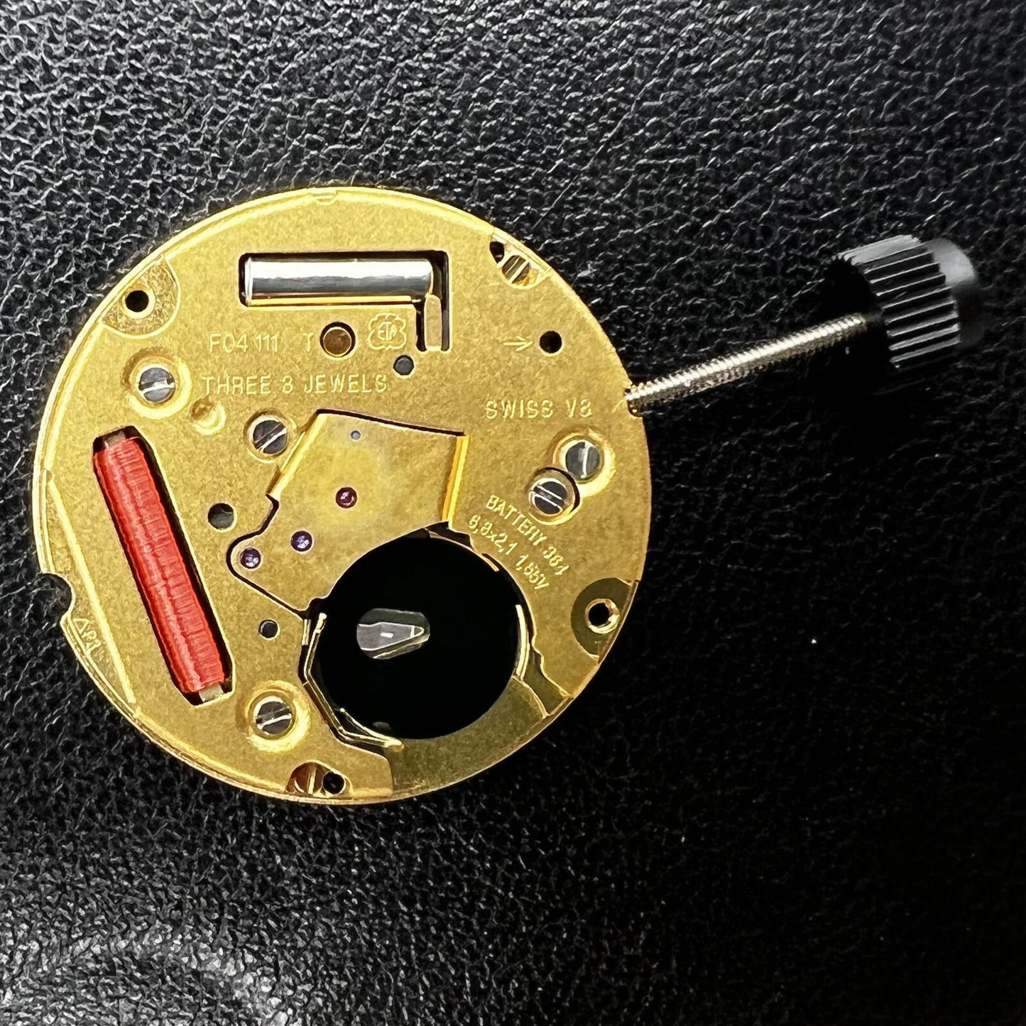 ETA F04.111 quartz watch movement with three hands and date, showcasing Swiss precision craftsmanship.