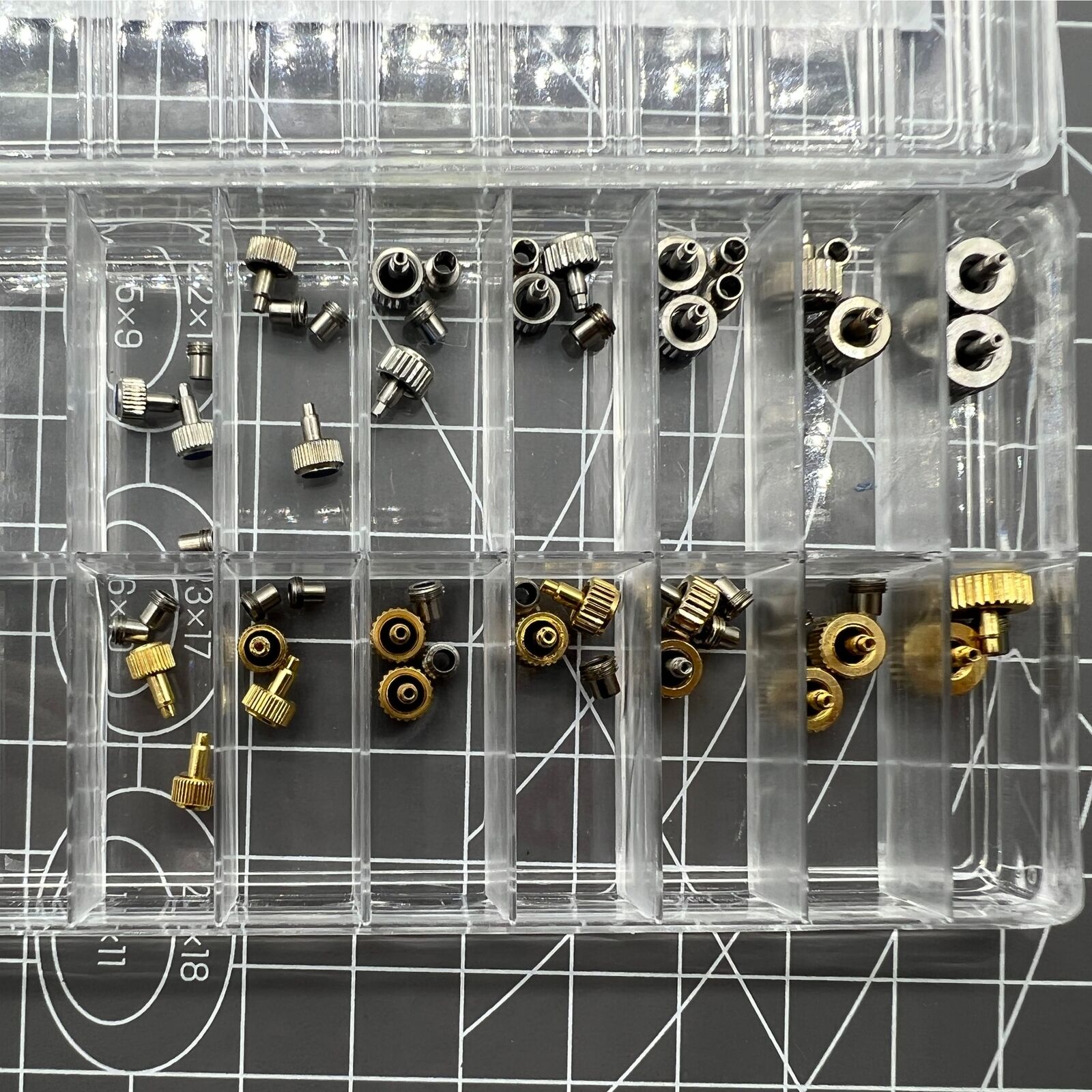 Silver and gold stainless steel screw-on watch crown with gasket, durable replacement accessory.