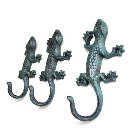 Vintage cast iron gecko-shaped wall hook for hanging cloth or garden tools, durable and rustic.