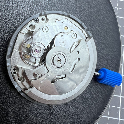 Seiko NH36A automatic watch movement with black finish and green luminescent markers, crown at 3:80 position.