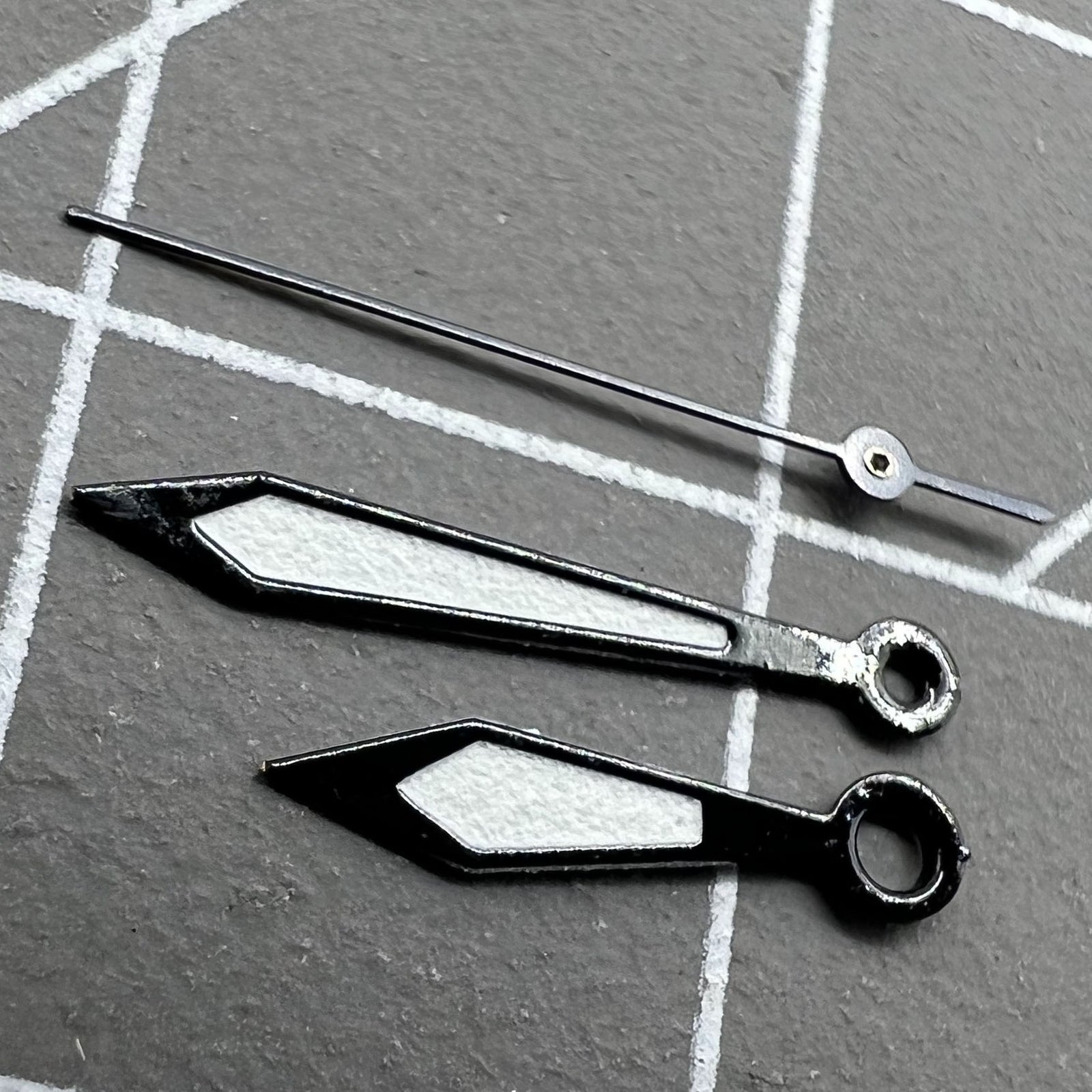 Two sets of 12mm black-trimmed white watch hands for Ronda 515 quartz watches.