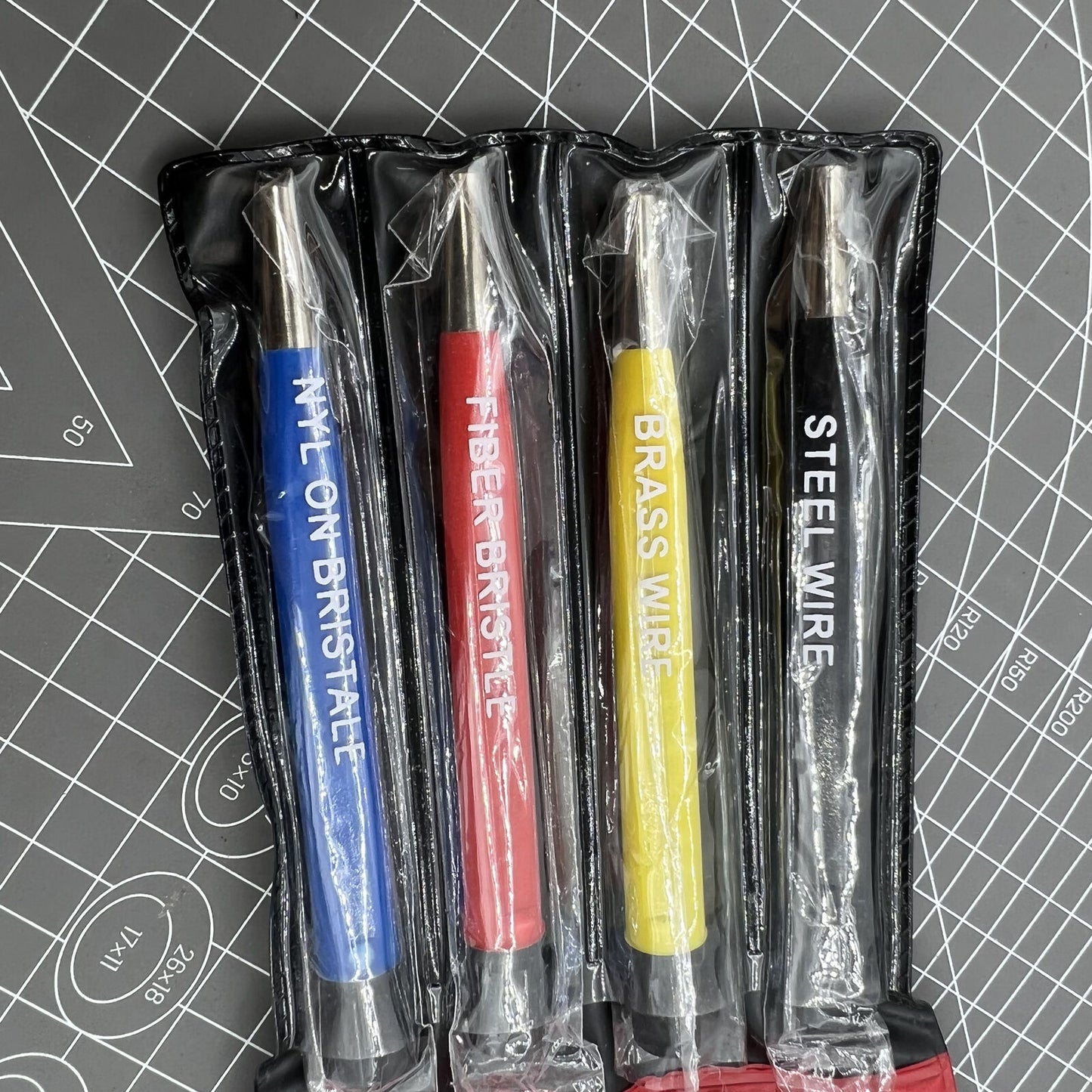 Scratch brush set with glass, steel, and nylon bristles for electronic watch repair.