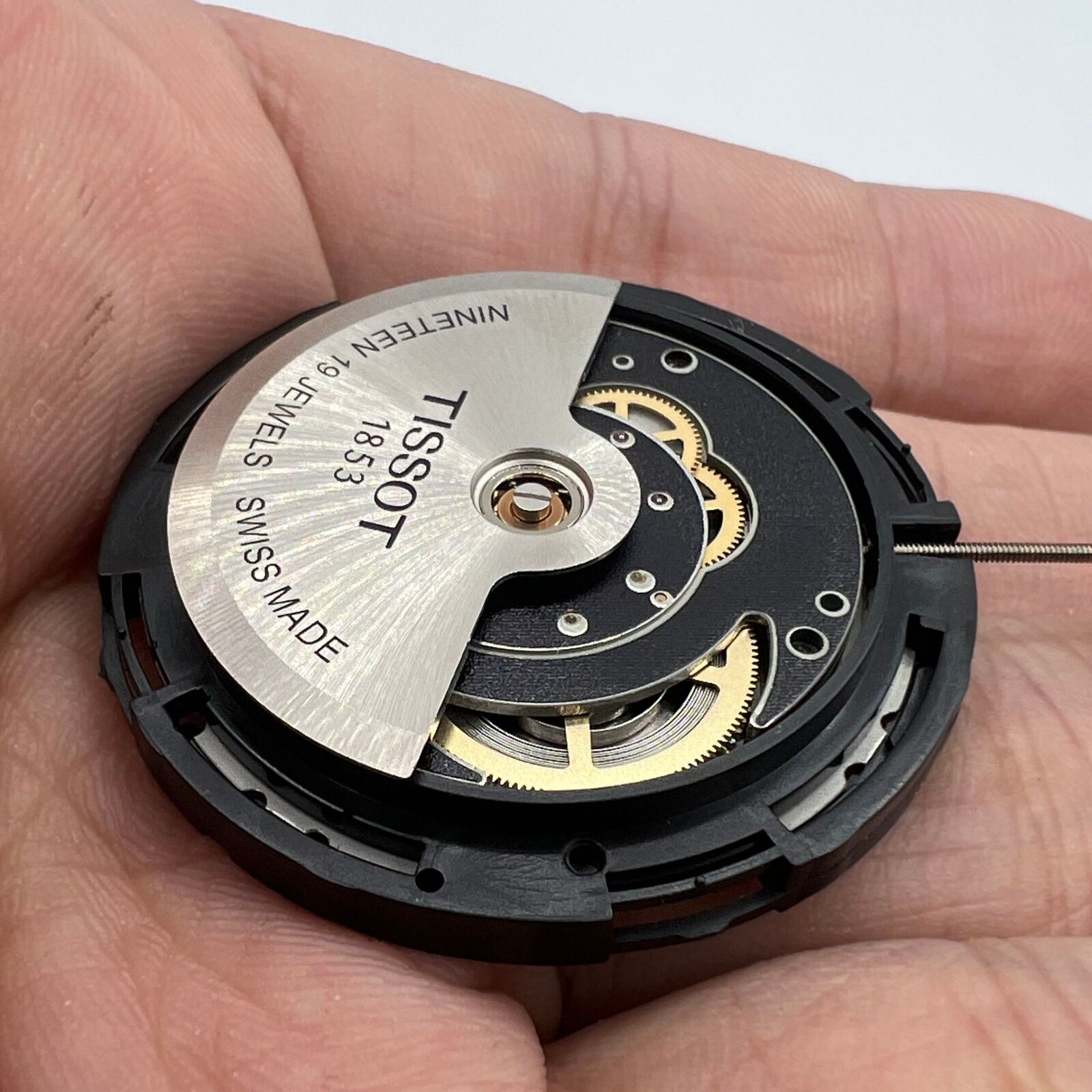 Close-up of Tissot ETA C15.111 chronograph watch movement with white dial, Swiss precision craftsmanship.