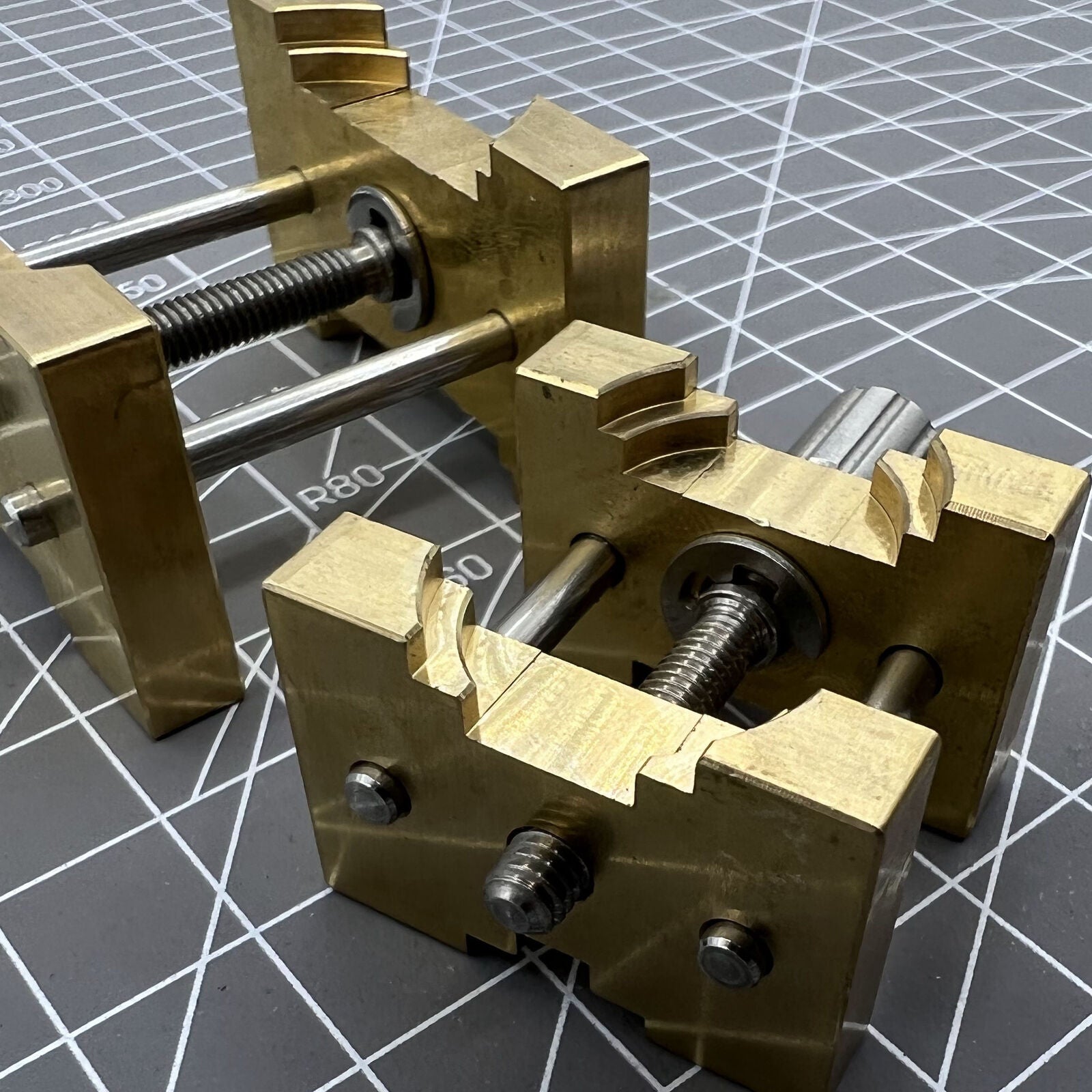 Copper watch movement holder clamp set, ideal for vintage watchmaker repairs and precision handling.