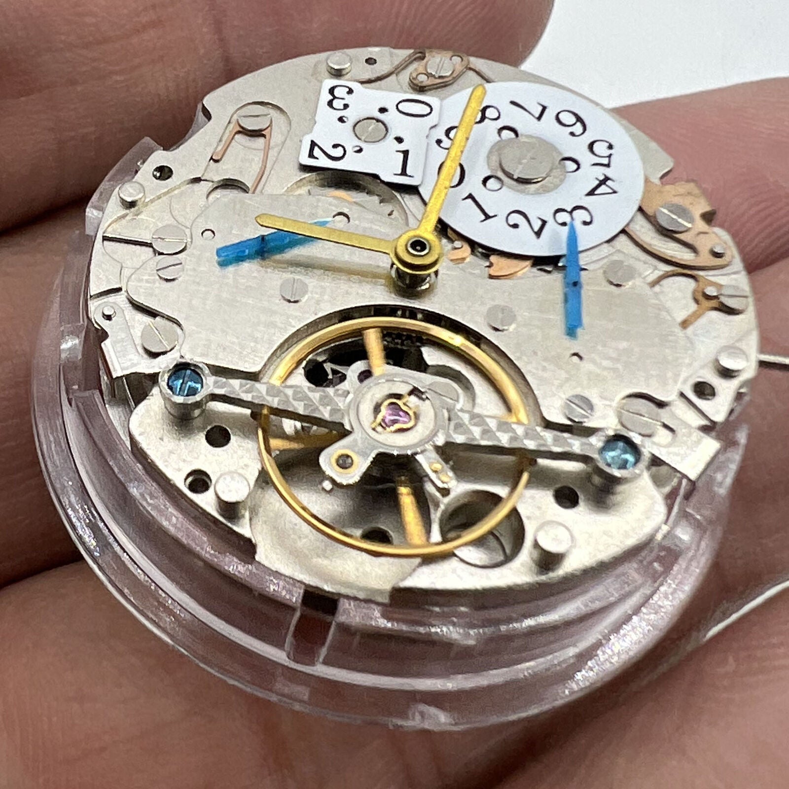 Asian multifunctional watch with date at 12, bare balance wheel, automatic mechanical movement.