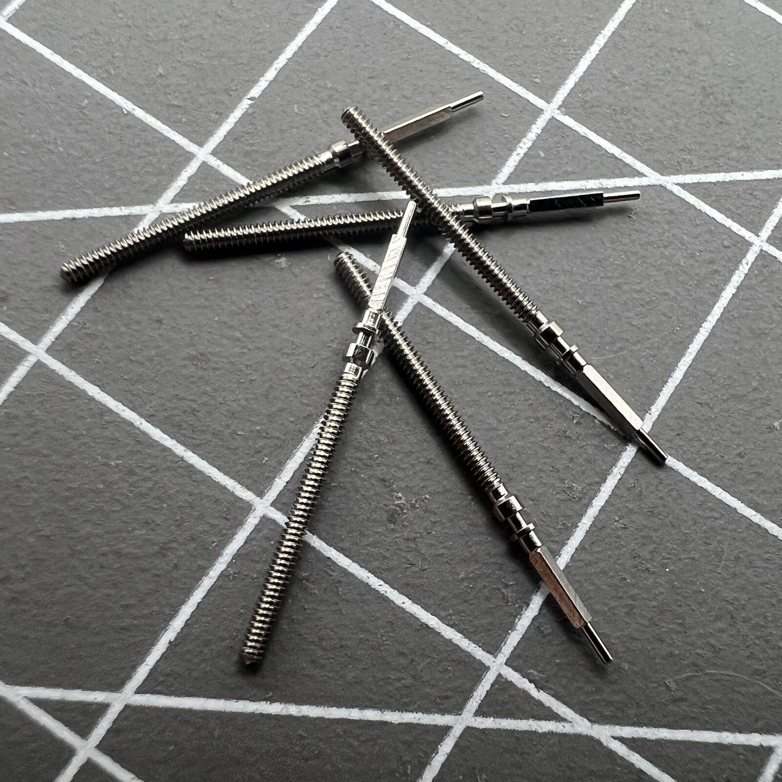 Precision watch winding stem for Omega 560 movement, high-quality replacement part for timekeeping repair.