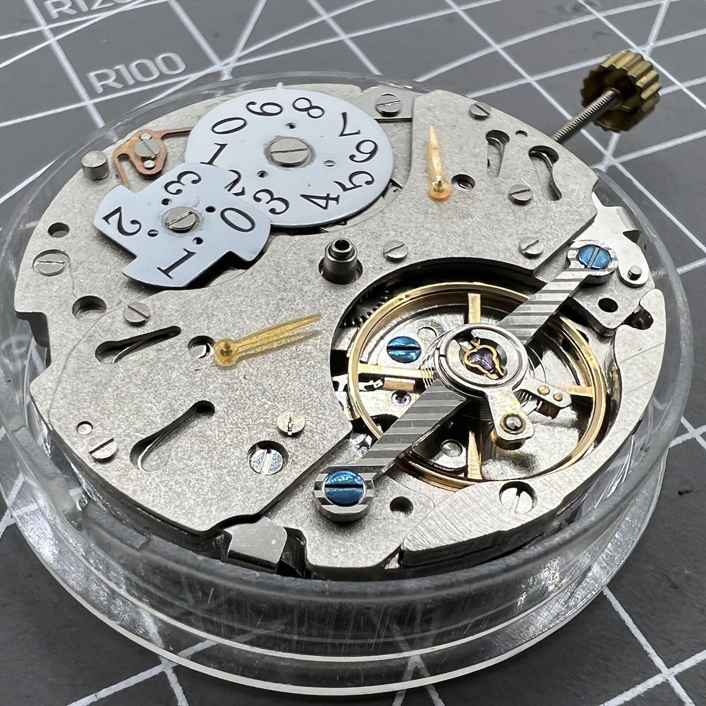 Automatic mechanical watch with reversed balance wheel and big date display at 12, showcasing precision craftsmanship.