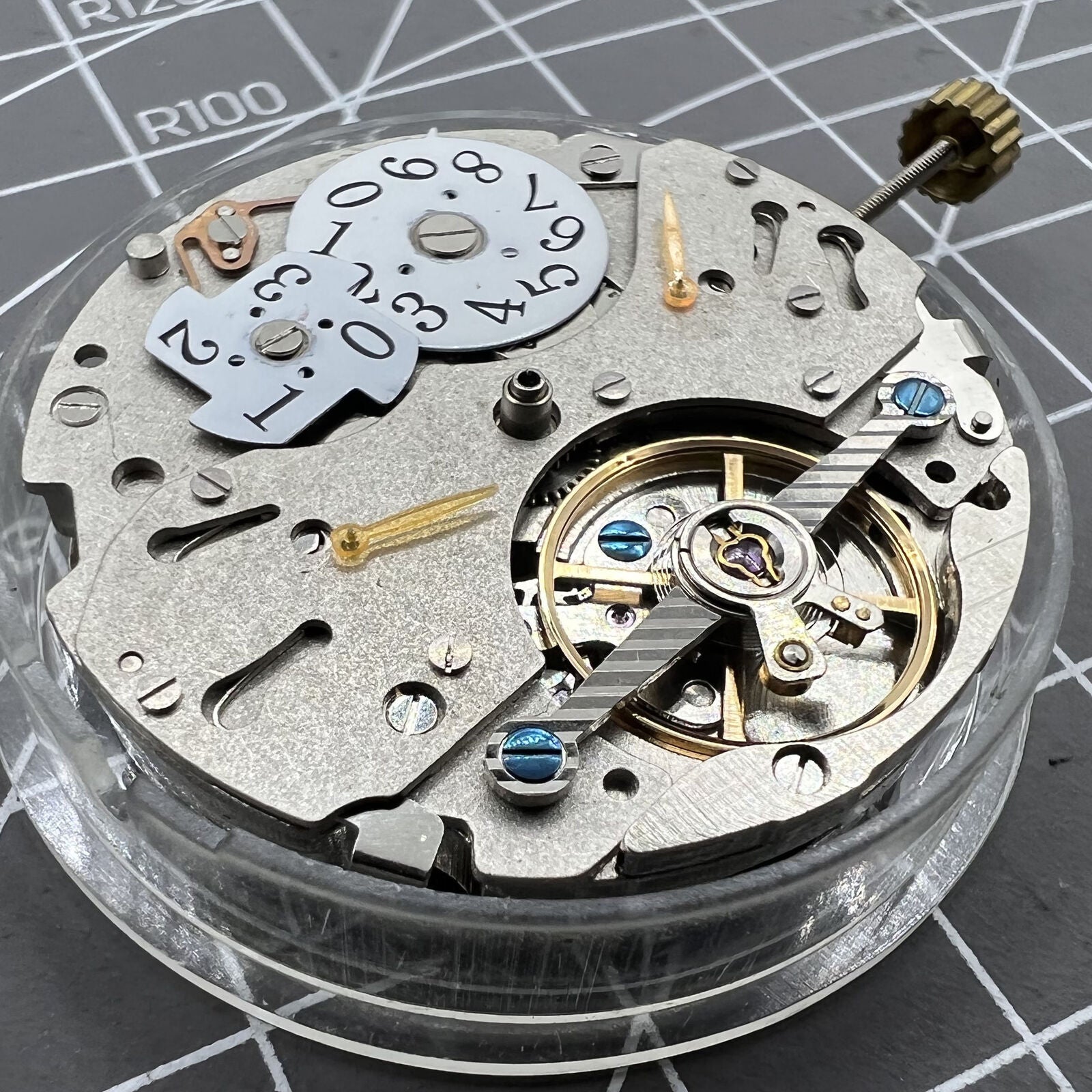 Automatic mechanical watch with reversed balance wheel and big date display at 12, showcasing precision craftsmanship.