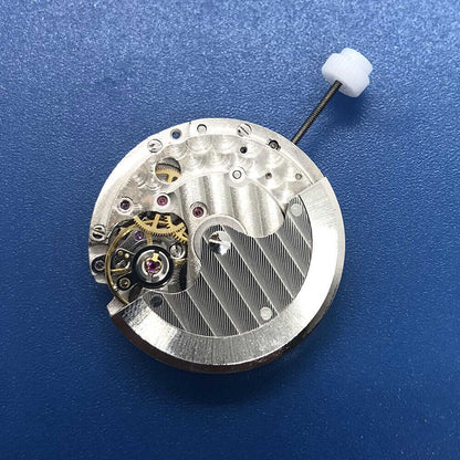 DG2813 automatic watch movement close-up with silver gears and date display at 3 o'clock, precision engineering.