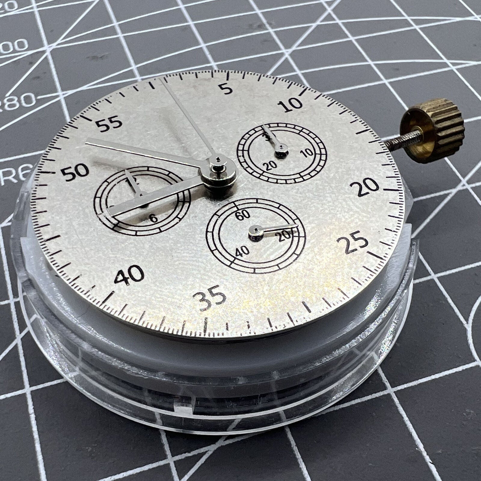 Close-up of China Made 7750 automatic chronograph movement with ETA 7753 configuration showing subdials at 3, 6, and 9 o'clock.