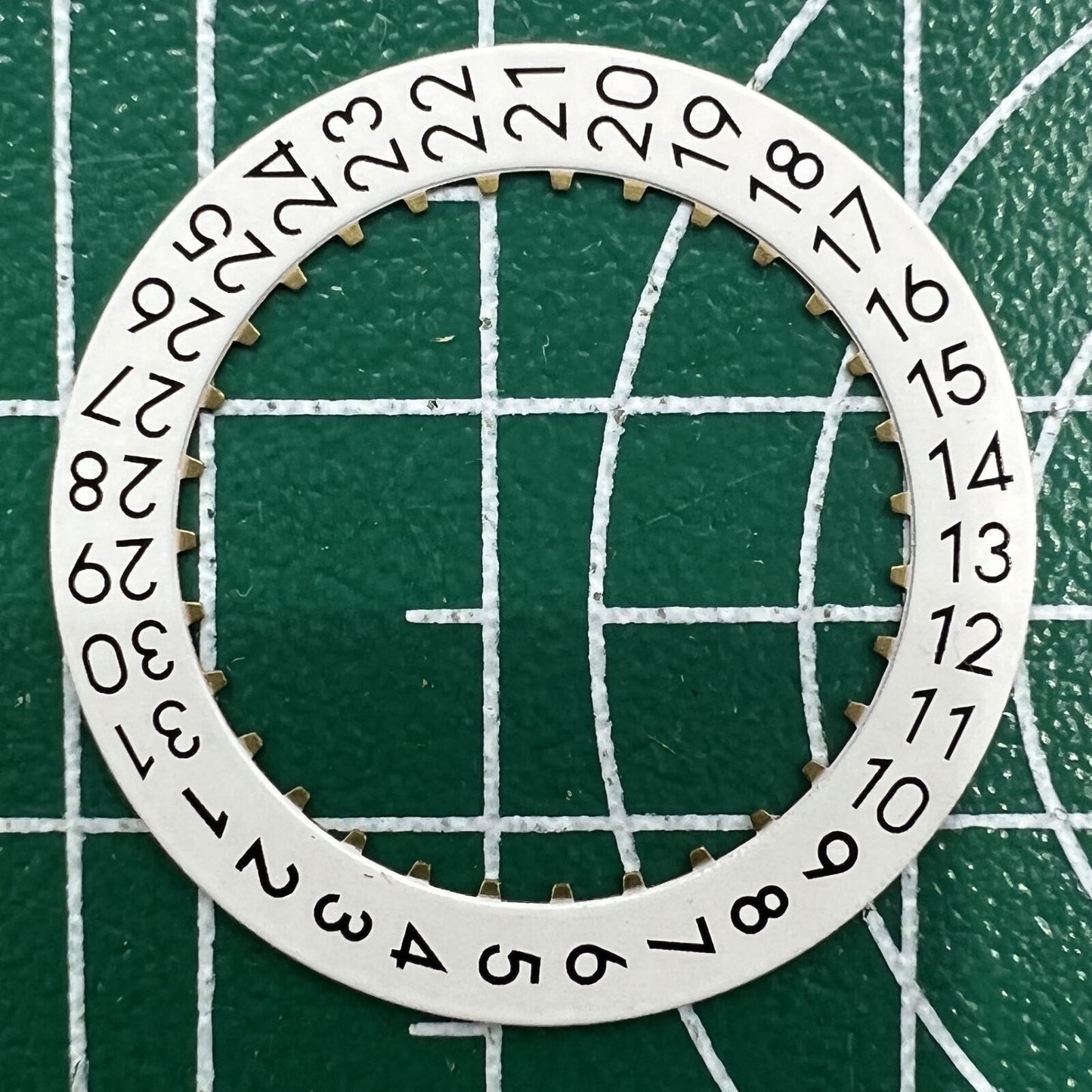 Wholesale lot of OM Font date wheels for ETA 2824 watches, showing date at 3 o?clock position.