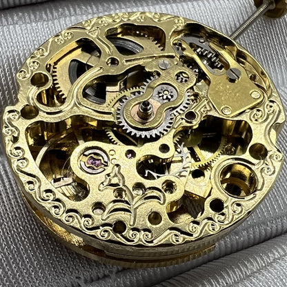 Golden 26.5mm 7120 automatic watch movement with intricate carved hollow design, precision