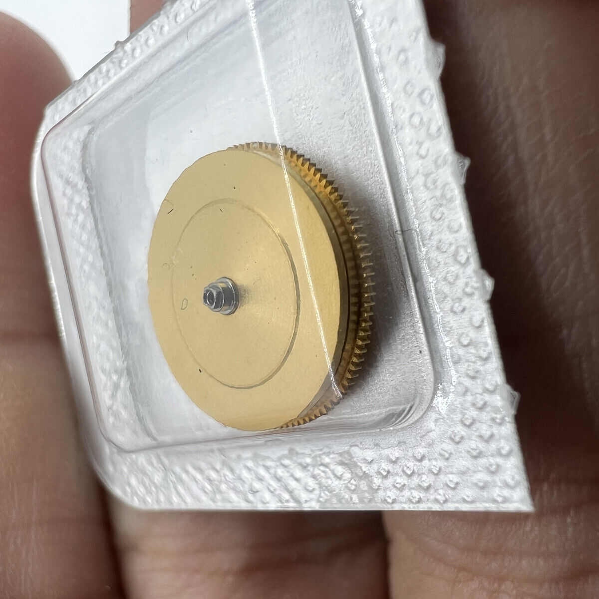 Omega 3303/3313 movement barrel with mainspring, precision watch accessory for repair and maintenance.