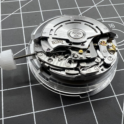 Close-up of Chinese 4130 automatic watch movement with small second subdials at 3, 6, and 9 o'clock for precision timekeeping.
