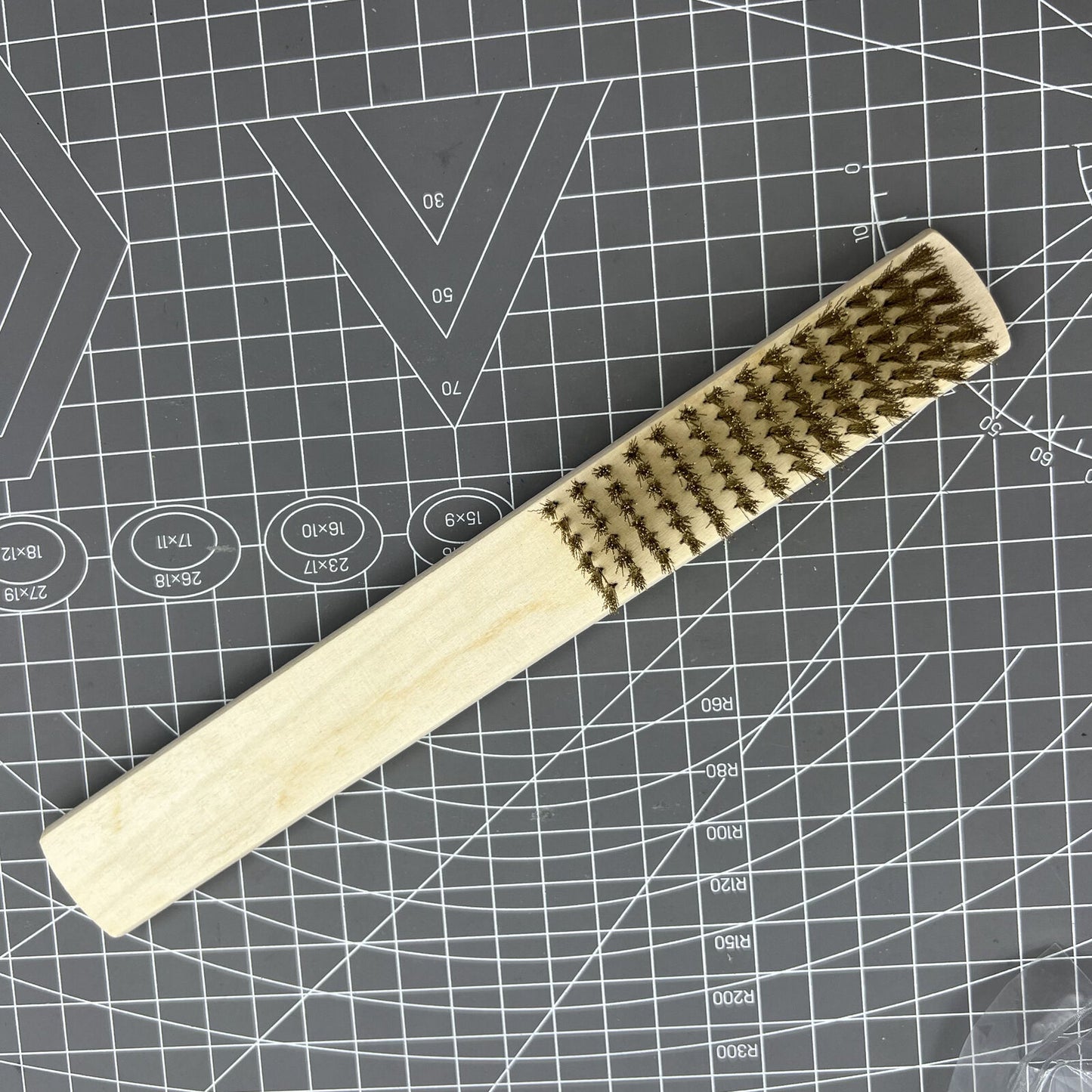 Copper wire brush with wooden handle for rust removal and metal cleaning, ideal for jewelry making tools.
