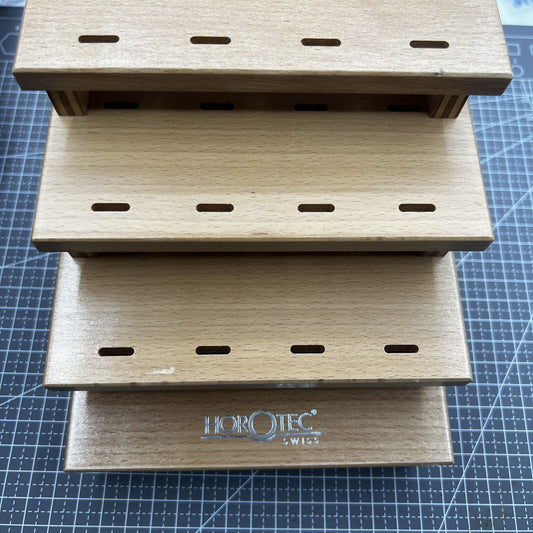 Swiss Horotec wooden storage rack holding 12 watchmaker tweezers, perfect for organized tool storage.